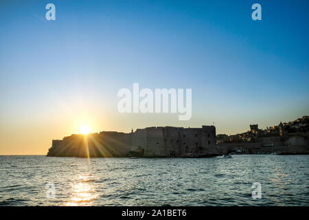 Una vista da una barca che si avvicina al paese vecchio di Dubrovnik porto o di porto vecchio, proprio come il sole tramonta sulla famosa Città Vecchia mura storiche Foto Stock