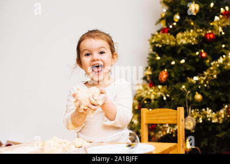 Entusiasta il toddler girl rendendo biscotti di Natale, pasta di tenuta a forma di cuore Foto Stock