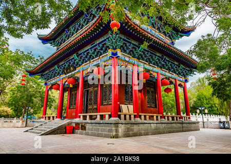 Urumqi Renmin Gongyuan persone parco del lago mozzafiato Pavilion con lanterne pendenti su un soleggiato Blue Sky giorno Foto Stock