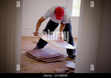 Generatore di sesso maschile il prelievo di materiali antichi da una stanza all'interno di una casa. Foto Stock