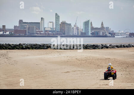 Bagnino RNLI sullato sabbia a nuovo sul lungomare di Brighton beach guardando verso la skyline di Liverpool Foto Stock