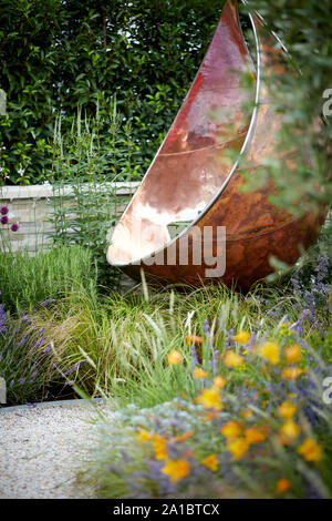 Il lusso moderno rilassante hanging sedie realizzate in rame su adorna area del giardino moderno Foto Stock