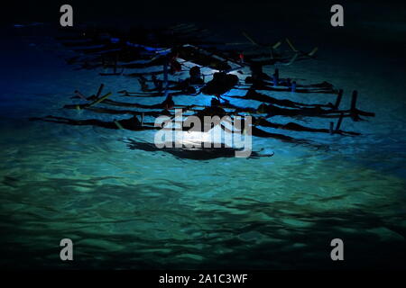 Tour notturno di immersione e snorkeling a Manta ray sulla costa di Kona alle Hawaii al tramonto. Foto Stock