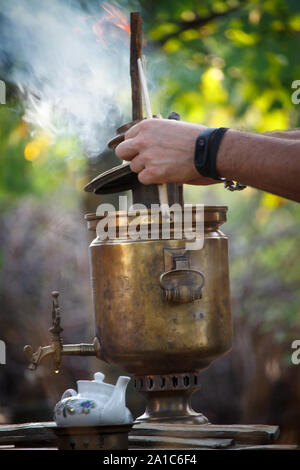 Innesco del bronzo antico samovar, posa di legna da ardere per riscaldare acqua per la preparazione del tè, il fuoco selettivo Foto Stock