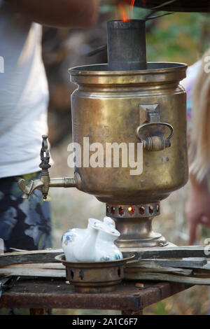 Innesco del bronzo antico samovar, posa di legna da ardere per riscaldare acqua per la preparazione del tè, il fuoco selettivo Foto Stock