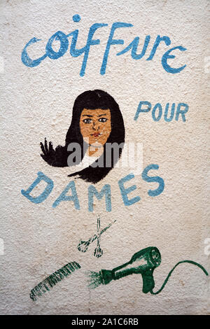 Un segno dipinta su un muro al di fuori di una donna parrucchiere nella città vecchia (medina di Tunisi, Tunisia. Foto Stock