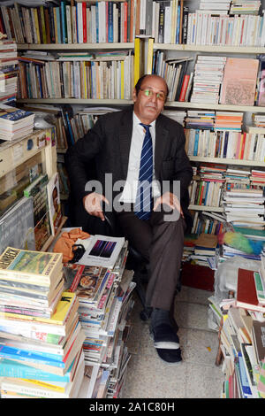 Un libraio tunisino seduta nel suo bookshop nel mercato della Kasbah, nella medina di Tunisi, Tunisia. Foto Stock