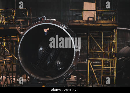 Lavoratore in una sporca e vecchia ma ancora funzionante di opere in metallo, vecchio stile, factory Foto Stock