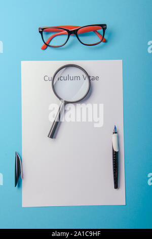 Curriculum vitae scritto su un vuoto di carta bianca su sfondo blu Foto Stock