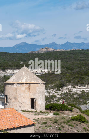 Vecchia Torre sullo sfondo di montagne, foreste e il cielo con le nuvole. A distanza di un turista prende una foto Foto Stock