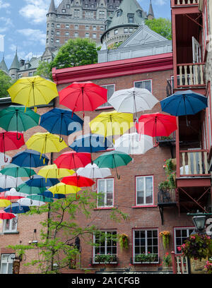 Ombrelloni formano un design unico nella parte inferiore della vecchia Quebec City, in Canada. Lo Chateau Frontenac è lo sfondo. Foto Stock