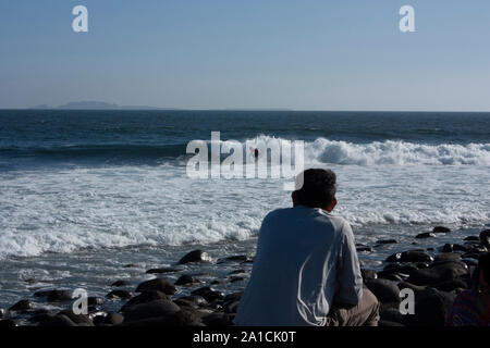 L'uomo ammirando la donna essendo piantato su una tavola da surf nel mare di Baja California ENSENADA Messico Foto Stock