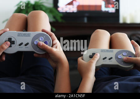 Due ragazzi che giocano a Super Nintendo insieme Foto Stock
