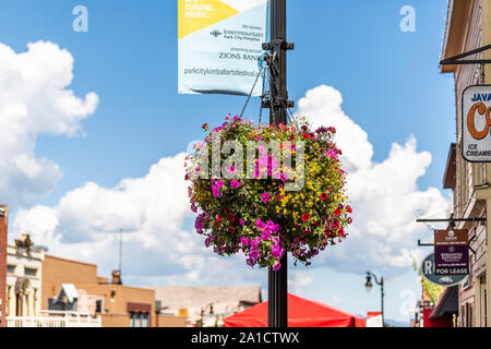 Park City, Stati Uniti d'America - Luglio 25, 2019: Ski resort town in Utah durante l'estate con il centro del fiore e cestello pensili pentole e banner Foto Stock