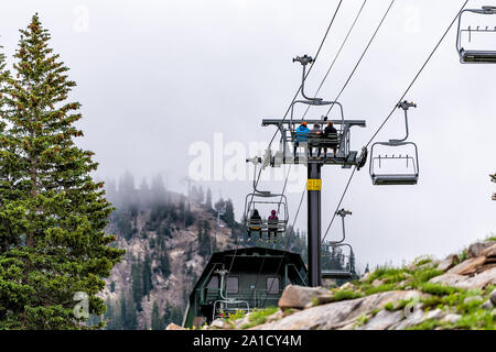 Alta, Stati Uniti d'America - 27 Luglio 2019: Albion bacino, Utah estate con persone ridging impianti di risalita in estate in montagne Wasatch con nebbia nebbia di mattina Foto Stock