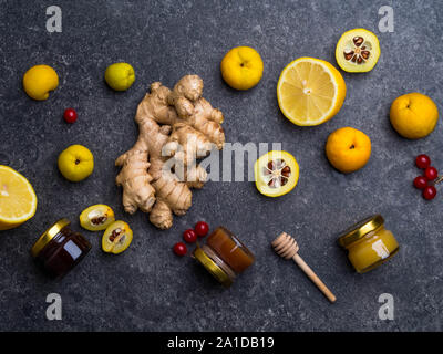 Medicina alternativa, gli ingredienti per un riscaldamento piccante tè nella giornata invernale, mangiare sano concetto, miele in vasetti di vetro, bacche rosse, Cydonia, limone, Foto Stock