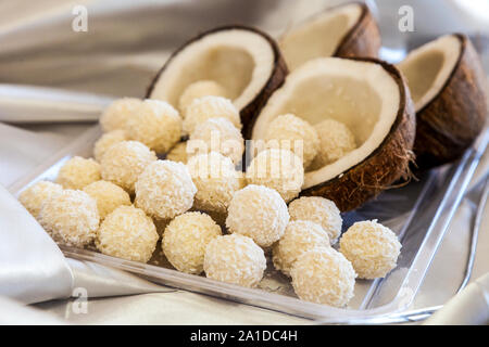 Di dolci al cocco e sfere di noce di cocco reale dietro di loro Foto Stock