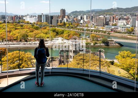 Donna che guarda dalla piattaforma di osservazione di Hiroshima Orizuru Tower, vista panoramica della città con la cupola della bomba atomica, la Cupola della Bomba Atomica e Foto Stock