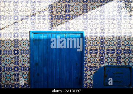 Una porta impostato in un colorato Muro di piastrelle a Essaouira, Marocco, Africa Foto Stock