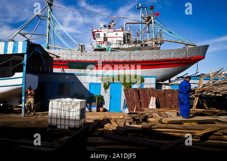 Un lavoratore prega al porto di Essaouira, Marocco, Africa Foto Stock