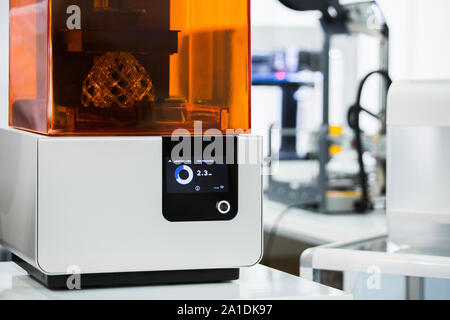 Un stereolitografia stampante 3d nel laboratorio di stampe una struttura da un fotopolimero. Foto Stock