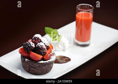 Coulant al cioccolato con fragole e more Foto Stock