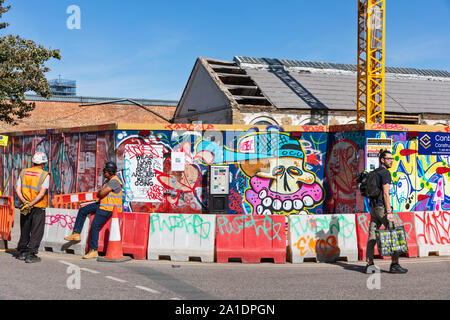 Coperto di graffiti accaparramento architettonico schermo schede di lavoro di costruzione a Hackney Wick, East London, Regno Unito. Foto Stock