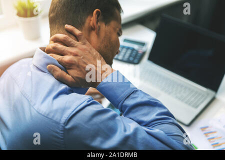 La sindrome di ufficio - uomo che soffre di dolori al collo e alla schiena mentre si lavora con il computer Foto Stock