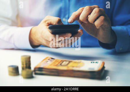 Concetto di fintech - imprenditore utilizzando smart phone per effettuare le transazioni finanziarie Foto Stock