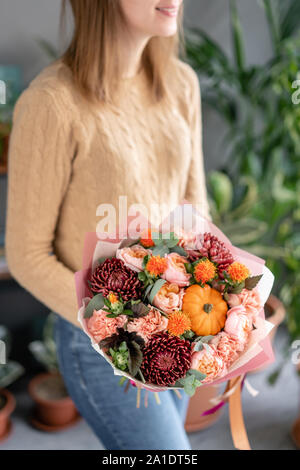 Autunno bouquet di fiori misti in womans mani. Il lavoro del fioraio presso un negozio di fiori. Fresh cut flower. Foto Stock