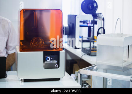 Un stereolitografia stampante 3d nel laboratorio di stampe una struttura da un fotopolimero. Foto Stock