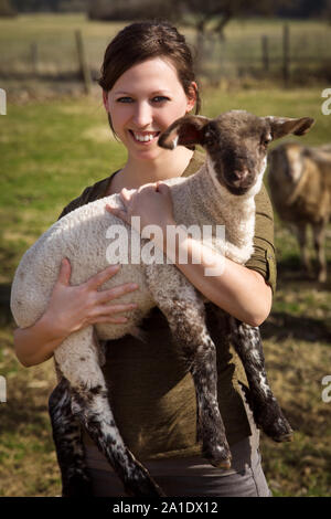 Donna che mantiene un agnello, concetto vegane e vita vegetariana Foto Stock