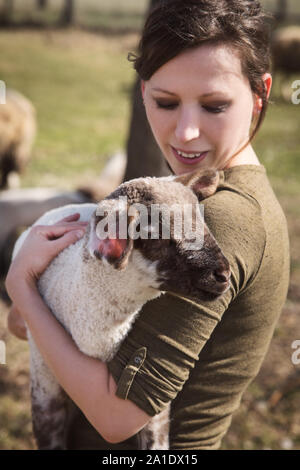 Donna che mantiene un agnello, concetto di animale-amare e protezione animale Foto Stock