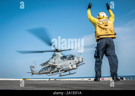 190917-M-QP663-1050 Golfo di Aden (sett. 17, 2019) di aviazione di Boatswain Mate (movimentazione) terza classe Kevin McAdam guide un AH-1Z Viper elicottero, attaccato al mezzo marino Tiltrotor Squadron 163 (rinforzato), undicesimo Marine Expeditionary Unit (MEU), durante la fase di decollo dal ponte di volo del trasporto anfibio dock nave USS John P. Murtha (LPD 26). Il Boxer anfibio gruppo pronto e undicesimo MEU sono distribuiti negli Stati Uniti Quinta Flotta area di operazioni a sostegno di operazioni navali per garantire stabilità marittimo e la sicurezza nella regione centrale di collegamento del Mediterraneo e del Pacifico attraverso il Foto Stock