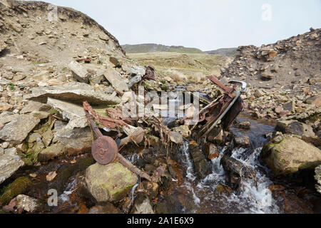 Abbandonati i resti di un veicolo e rottami di metallo in un ruscello vicino alle vecchie miniere di piombo sulla strada Oxclose, Ivy cicatrice, tra Woodhall e a Carperby, Yorkshire Foto Stock