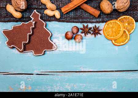 Gingerbread cookie con i dadi, inverno spezie e fettine di arancia sul tavolo di legno, copyspace Foto Stock