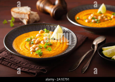 Carota cremosa zuppa di ceci su scuro dello sfondo rustico Foto Stock