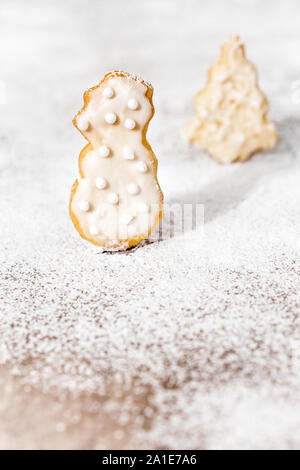 Pupazzo di neve e albero di natale di biscotti di forma sulla glassa di zucchero bianco, biglietto di auguri con copyspace Foto Stock