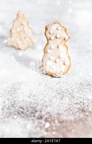 I cookie che pupazzo di neve e albero di natale forma, zucchero a velo e nevicata, copyspace Foto Stock