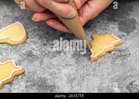 Lo zucchero baker la decorazione luminosa i biscotti con la glassa reale o glassa, concetto fabbricazione e area di lavoro Foto Stock