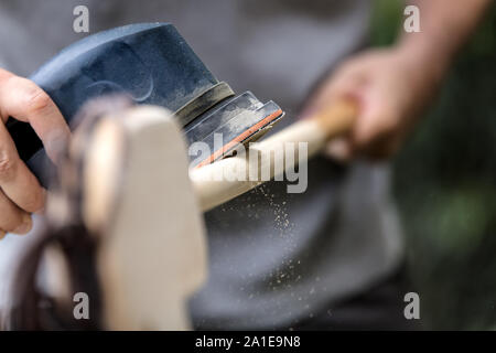 L uomo è un abrasivo hobbyhorse con una smerigliatrice elettrica Foto Stock