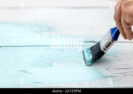 Tavole di legno che viene dipinta in shabby chic guardare da un uomo Foto Stock