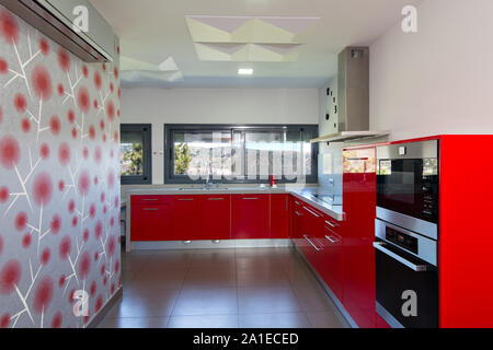 Cucina moderna in rosso, con vista esterna. Il design degli interni di casa. Foto Stock