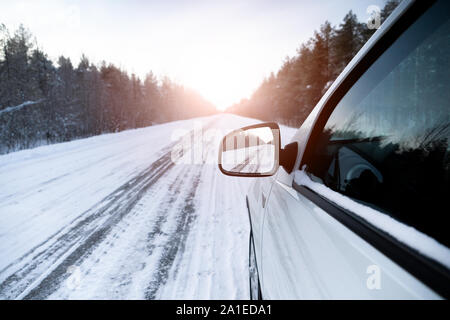 La strada in inverno è riflessa nella macchina del retrovisore Foto Stock