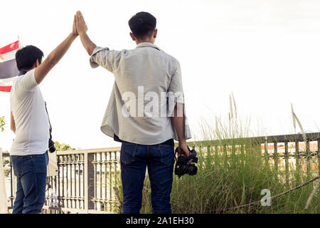 I turisti maschi di scattare foto con una fotocamera mentre si è in viaggio. Le gite sono paesaggi fotografati in Thailandia. Un gruppo di uomini sono in piedi la fotografia sul th Foto Stock