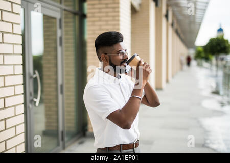 Uomo che parla al telefono cellulare e di bere il caffè Foto Stock