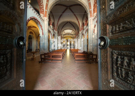 Basilica di Sant'Ambrogio (stile romanico) - Vista degli interni dall'atrio con apri porta di legno - Milano Foto Stock