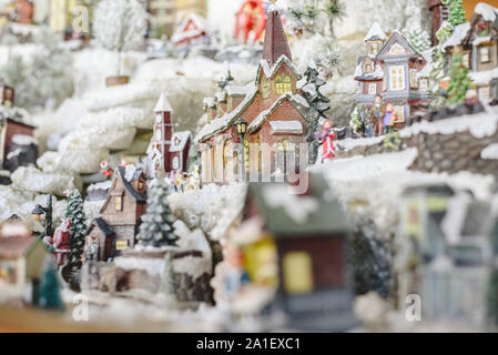 Le figure e le decorazioni di Natale in stile nordico, case in miniatura con un villaggio innevato. Foto Stock