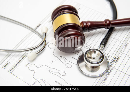 Un giudice in legno martello e uno stetoscopio su un diagramma di medici. Medical controversia concetto. Foto Stock