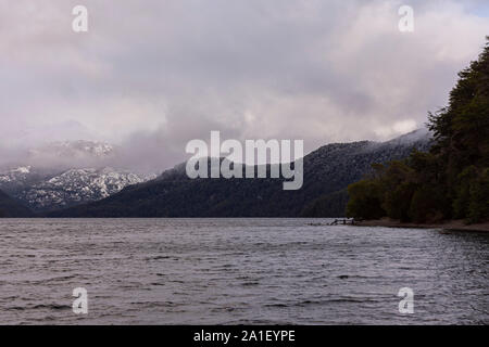 Vista scena del lago Futalaufquen contro innevate montagne delle Ande in una giornata grigia a Los Alerces National Park, Patagonia, Argentina Foto Stock